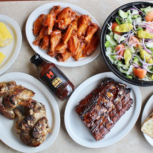 A feast of Hub's Restaurant's BBQ ribs, chicken, buffalo wings, corn, and a fresh Greek salad.